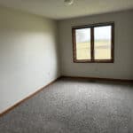 Empty room with window overlooking a field.