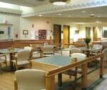 Hospital waiting room with chairs and tables.