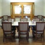 Traditional dining room with large wooden table and chairs.